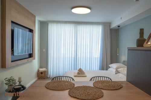 埃拉特Sea side "Tulip" apartment - by Rently的一间卧室配有一张床和一张桌子及两把椅子