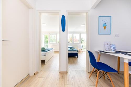 巴拉顿诺尔马迪Balaton Wave Apartments的客厅配有桌子和蓝色椅子