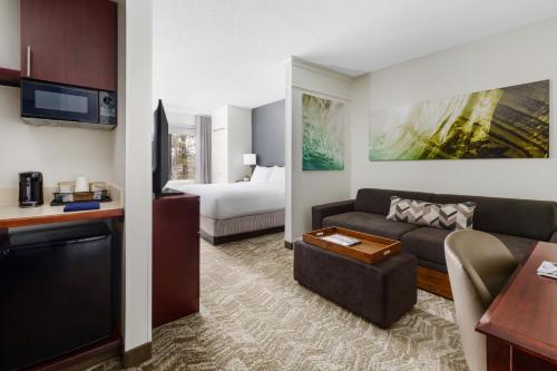 曼切斯特曼彻斯特波士顿地区机场春季山丘套房酒店的客厅配有沙发和1张床
