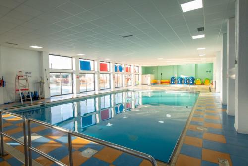 滨海克拉克顿Vacation Escape - Valley Farm -Clacton-on-sea - Holiday Park的大楼内的一个蓝色海水游泳池