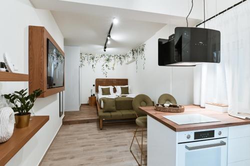 普雷韦扎Sabbia Mini Pool Suites的厨房以及带沙发和电视的客厅。