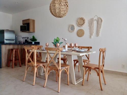 艾库玛尔Condominio en la Riviera Maya的一间配备有白色桌椅的用餐室