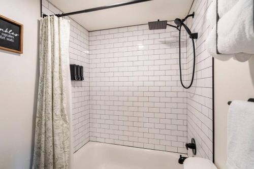 盐湖城Lady Madonna Sage Flat的浴室内铺有白色瓷砖并配有淋浴帘的淋浴间