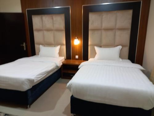 塔伊夫الملاك بارك的配有白色床单的酒店客房内的两张床