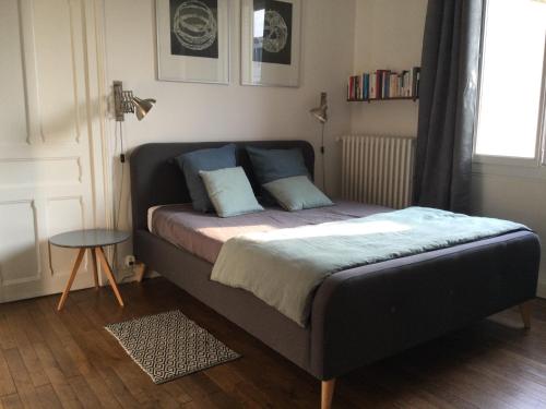 图尔L'APPART de 75 m², déco sympa à Tours的卧室内的一张带两个枕头的床