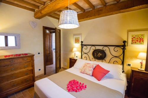 托迪BorgoCuore的一间卧室配有一张红色鲜花的大床
