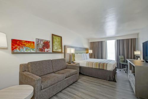新奥尔良Country Inn & Suites by Radisson, New Orleans I-10 East, LA的酒店客房设有一张沙发和一张床