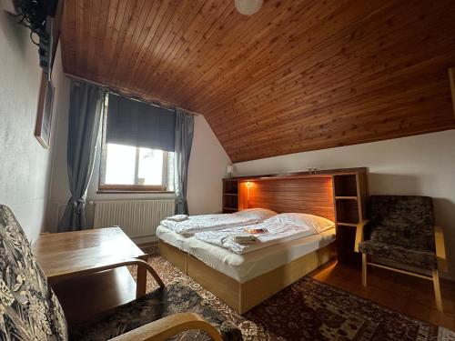 VlachovicePenzion Harvanek的一间卧室设有一张床和木制天花板