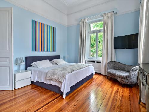 雅典The White House in Plaka by JJ Hospitality的卧室拥有蓝色的墙壁,配有一张床和椅子
