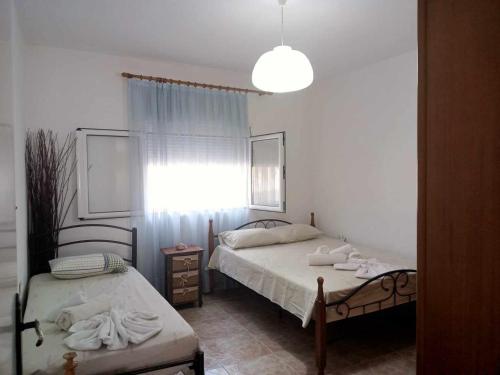 耶拉基尼COUNTRY HOUSE IN OLIVE GROVE - Gerakini的一间卧室设有两张床和窗户。