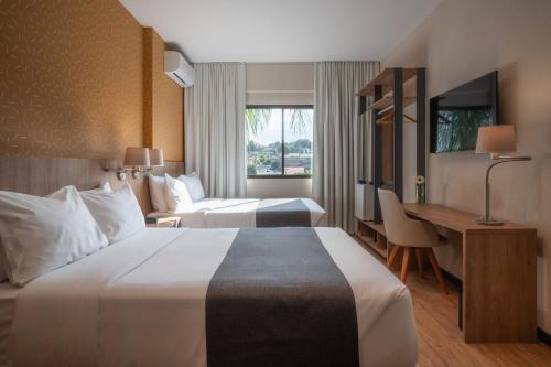 里韦拉Like Design Hotel Rivera的酒店客房设有一张大床和一张书桌。