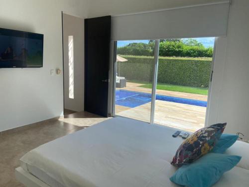 吉拉尔多特Girardot Casa estilo mediterraneo con piscina privada的一间卧室设有一张大床和一个大窗户