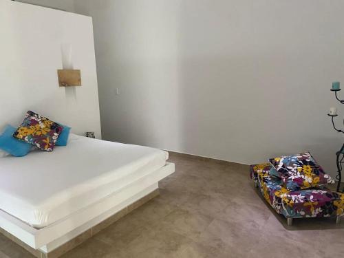 吉拉尔多特Girardot Casa estilo mediterraneo con piscina privada的一间白色卧室,配有一张床和两把椅子