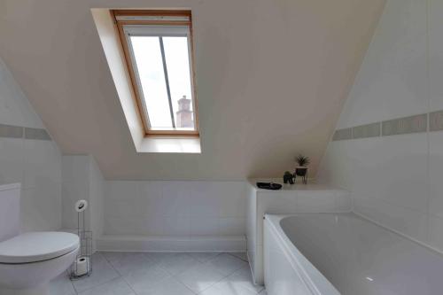 Elizabeth II Five Bedroom Spacious Home的白色的浴室设有卫生间和浴缸。
