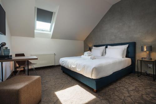 比尔森Riverside Hotel Plzeň的一间卧室配有一张大床和一张书桌