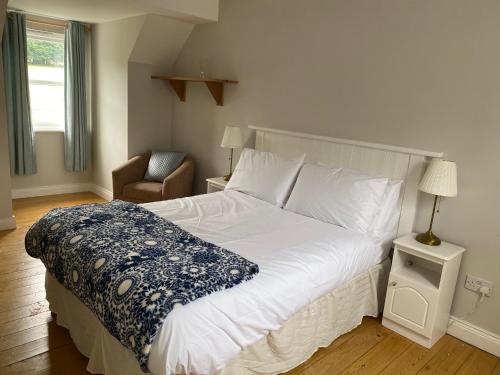 奥赫里姆No 3 Aughrim Holiday Village的卧室配有一张白色大床和一把椅子