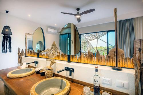 奥尔沃克斯岛Hotel Villas Flamingos的一间带水槽、两面镜子和窗户的浴室