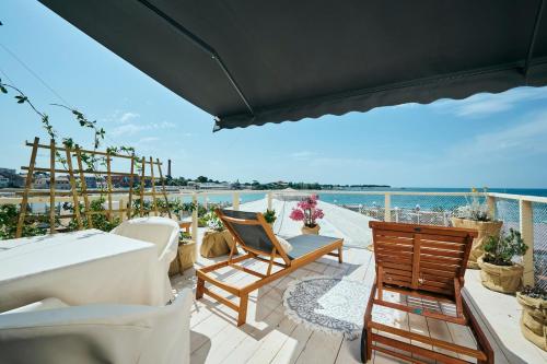 乌马格San Marco Luxury Rooms Umag的一个带桌椅的海景阳台