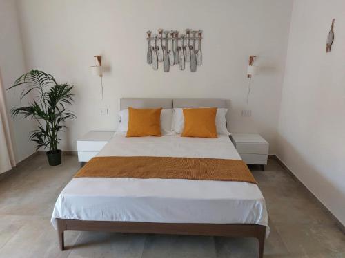 兰佩杜萨Le Barche Volanti的一间卧室配有一张带橙色枕头的大床
