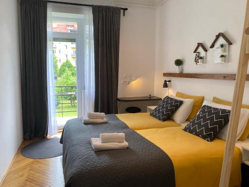卢布尔雅那Boennium Apartments Green Oasis的一间卧室配有两张带毛巾的床