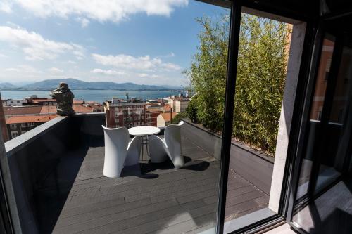 桑坦德Hotel Art Santander的设有一个配有桌椅并享有美景的阳台。