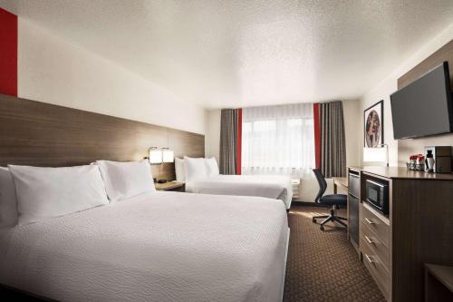 海伦娜Ramada by Wyndham Helena的酒店客房设有两张床和电视。
