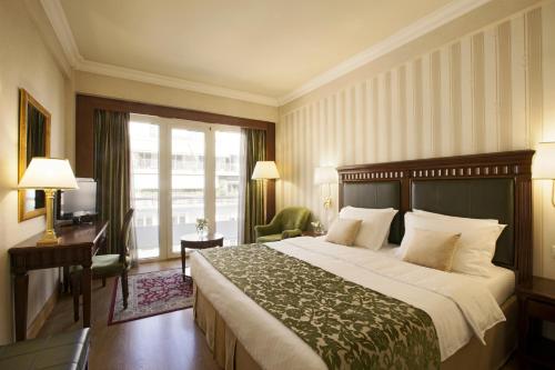 雅典雅典伊莱克特拉酒店的一间设有大床和窗户的酒店客房