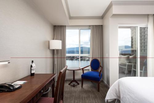 基洛纳Manteo at Eldorado Resort的酒店客房设有一张桌子、一张床和一个窗户。