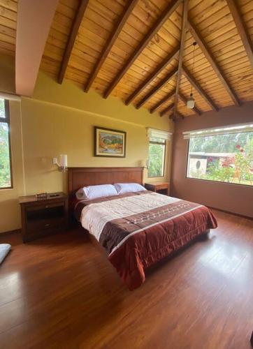 里奥班巴Casa de campo Guano Ecuador的铺有木地板的客房内设有一间卧室和一张床。