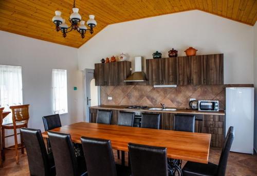 Harsány豪尔沙尼旅馆的厨房配有木桌和冰箱。