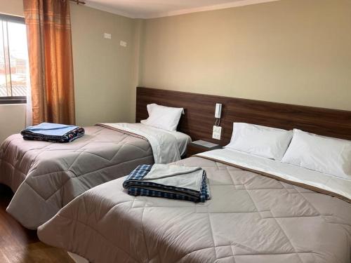 查查波亚斯Ayña Hotel的两张位于酒店客房的床,配有毛巾