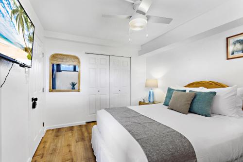 卡哈纳Kahana Villa F407的一间白色卧室,配有床和电视