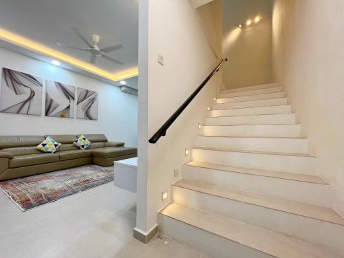 边佳兰RAPID Pelali Pengerang Homestay的客厅的楼梯,配有沙发