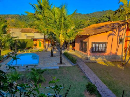 米格尔-佩雷拉Villa Terracotta的享有带游泳池和棕榈树的别墅的空中景致