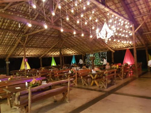 InhaúmaHotel Fazenda Coninho的餐厅设有木桌、椅子和吊灯。