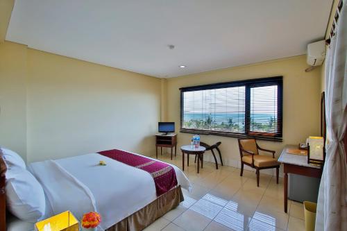 纳闽巴霍科莫多弗洛雷斯雅加达套房酒店的配有一张床、一张书桌和一扇窗户的酒店客房