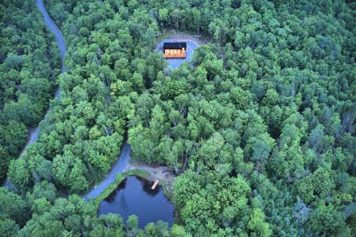 苏必利尔湖KALLM-Mont-Tremblant chalet with hot tub, pond & beach on private 7acre estate的森林中间房屋的空中景观