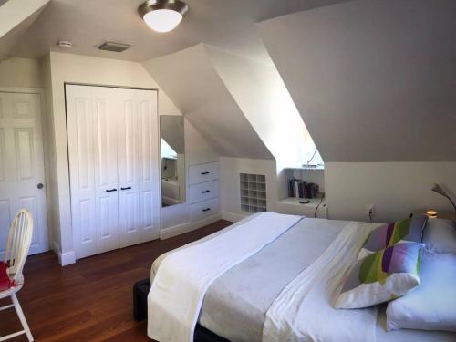 迈阿密Cozy Chalet near the Design District的卧室设有一张白色大床和楼梯。
