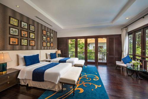 岘港Luxury Danatrip Villas的一间带两张床的卧室和蓝色地毯