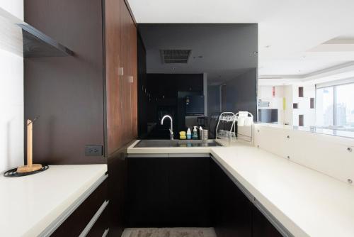 曼谷M Estate 2BR Private Residence, 300m to BTS Chit Lom的黑白厨房配有水槽和柜台