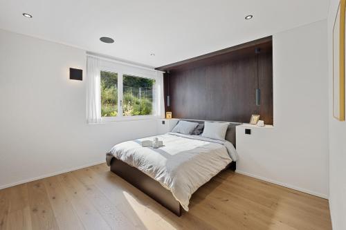 盖罗尔德斯维尔The R Apartment Uetliberg, Klima, Parken - Wallbox的一间卧室设有一张大床和一个窗户。