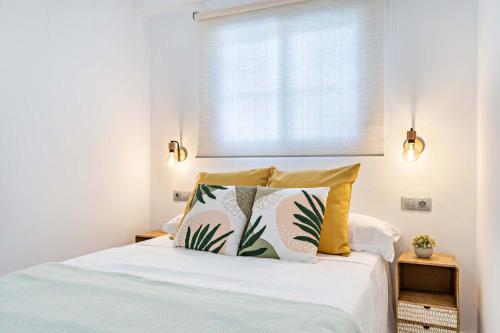 滨海罗克塔斯Elegante Apartamento cerca al mar的一间卧室配有带两个枕头的床和窗户
