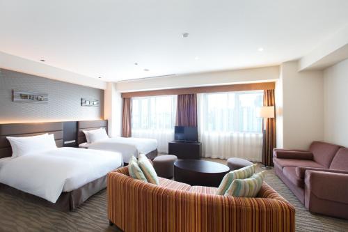 大阪大阪难波假日酒店的酒店客房,设有两张床和一张沙发