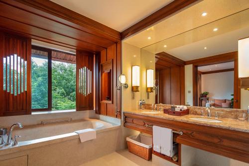 景洪市西双版纳安纳塔拉度假酒店的浴室配有2个盥洗盆、浴缸和大镜子