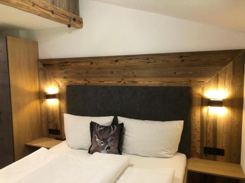 迈尔霍芬托马斯乡村旅馆的卧室配有白色的床和木制床头板