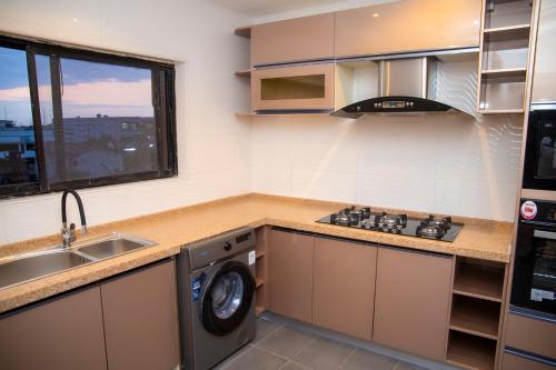 拉各斯MOBAK APARTMENT的厨房配有水槽和洗衣机