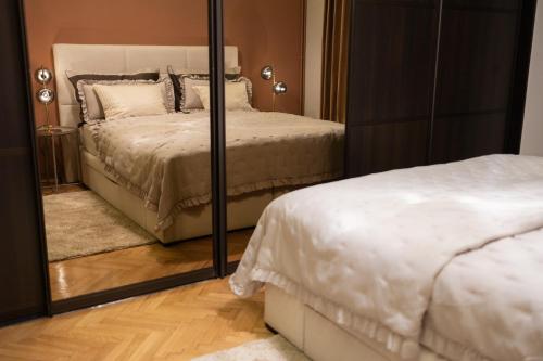 萨格勒布Bristol Apartment in the Centre of Zagreb的卧室配有镜子,位于床边