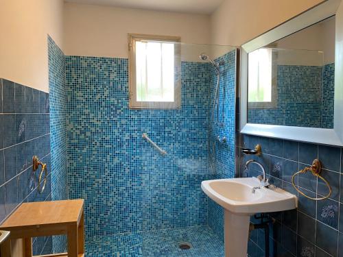 菲加里Casa Minnana的蓝色瓷砖浴室设有水槽和淋浴