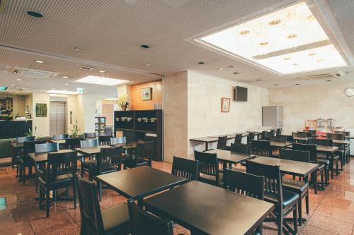 挂川市吴竹挂川旅馆的用餐室配有桌椅