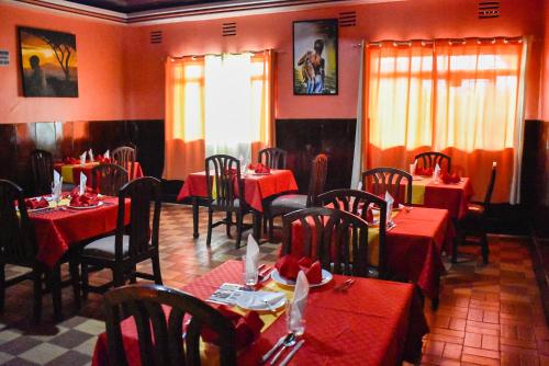 纳库鲁Sundowner Lodge的一间餐厅,房间内设有红色的桌椅